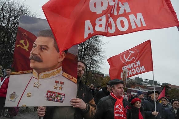 07.11.2022, Russland, Moskau: Anh�nger der Kommunistischen Partei tragen ein Portr�t des Diktators Josef Stalin w�hrend einer Demonstration zum 105. Jahrestag der bolschewistischen Revolution von 1917 ...