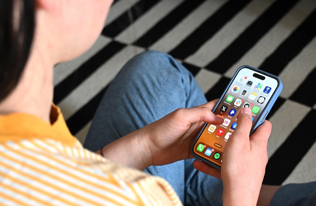 SYMBOLBILD - 17.05.2025, Sachsen, Leipzig: Eine Jugendliche sitzt auf dem Boden und nutzt ein Smartphone - auf dem Display sind verschiedene Apps zu sehen. Ob Social Media, Chats oder Spiele: Das Smar ...