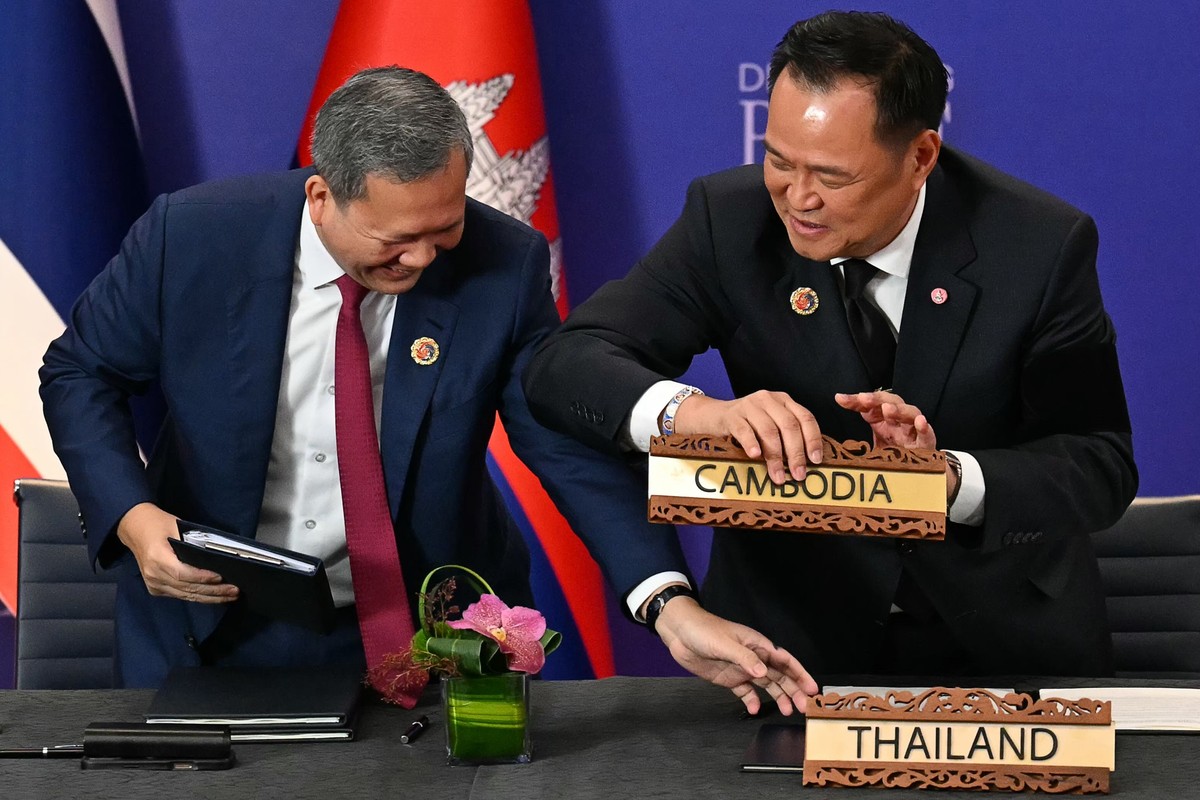 Thailand&#039;s Prime Minister Anutin Charnvirakul, right, and Cambodia&#039;s Prime Minister Hun Manet change their seats during the ceremonial signing of a ceasefire agreement between Thailand and C ...