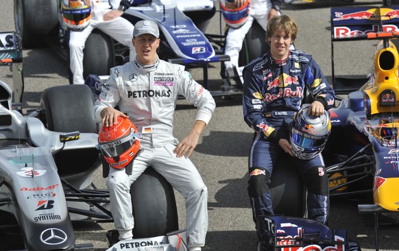 FILE - Mercedes Grand Prix driver Michael Schumacher of Germany, left, and Red Bull driver Sebastian Vettel of Germany, right, pose for photographs on the track before the first practice session at th ...