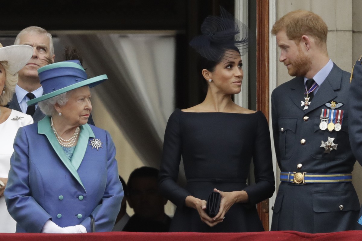 ARCHIV - 10.07.2018, Gro�britannien, London: Die britische K�nigin Elizabeth II. (l-r), Meghan, Herzogin von Sussex, und der britische Prinz Harry, Herzog von Sussex, stehen auf einem Balkon und beoba ...