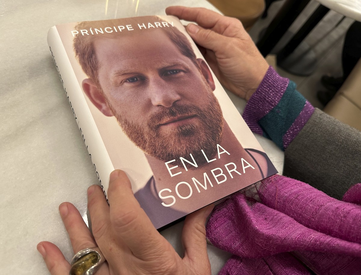 A woman holds a copy of "En La Sombra" (In the Shadow), the Spanish translation of Prince Harry's memoir, "Spare," in Barcelona, Spain, Thursday Jan. 5, 2023. Prince Harry all ...