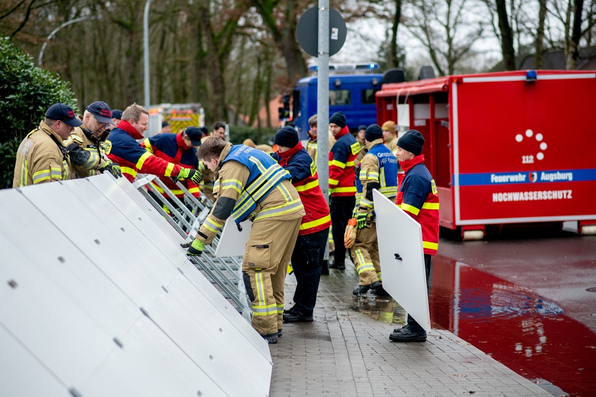 01.01.2024, Niedersachsen, Oldenburg: Einsatzkr�fte der Feuerwehr stellen einen mobilen Deich im Stadtteil B�mmerstede auf. Zahlreiche Helfer sind in der Stadt Oldenburg und im Landkreis Oldenburg unt ...