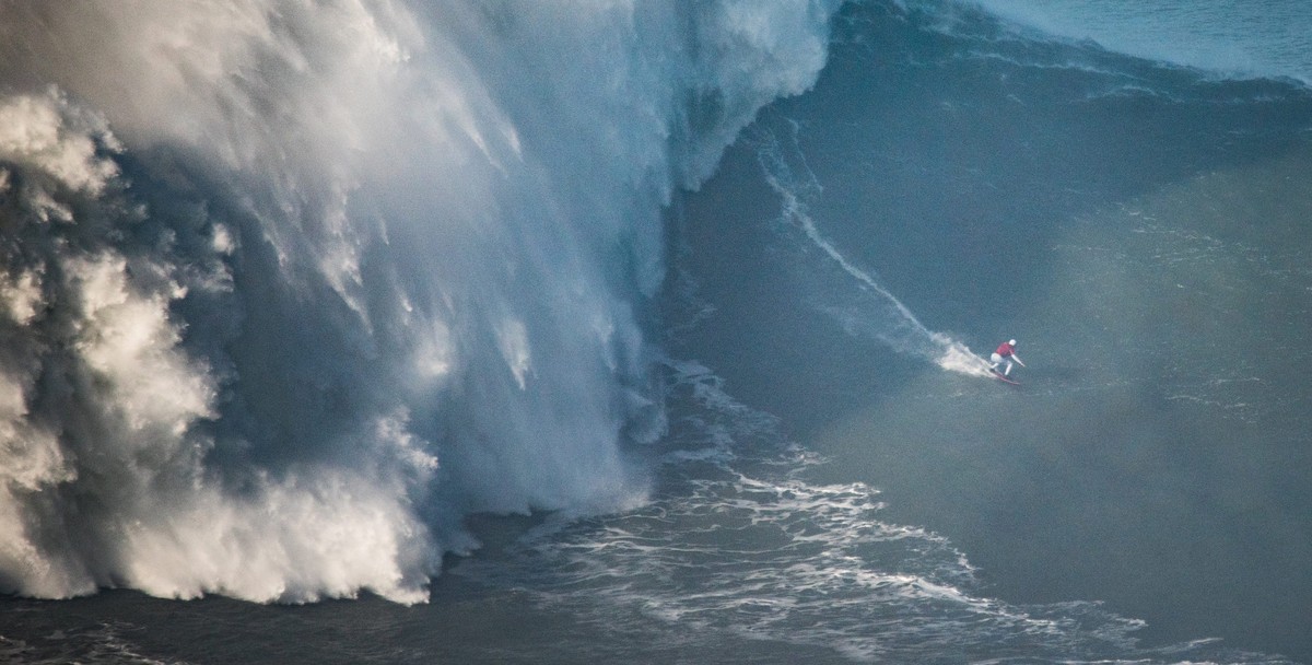 ARCHIV - 01.10.2018, Portugal, Nazare: Maya Gabeira aus Brasilien surft eine 20,72 Meter hohe Welle. Die Brasilianerin hat 2020 ihren eigenen Weltrekord f