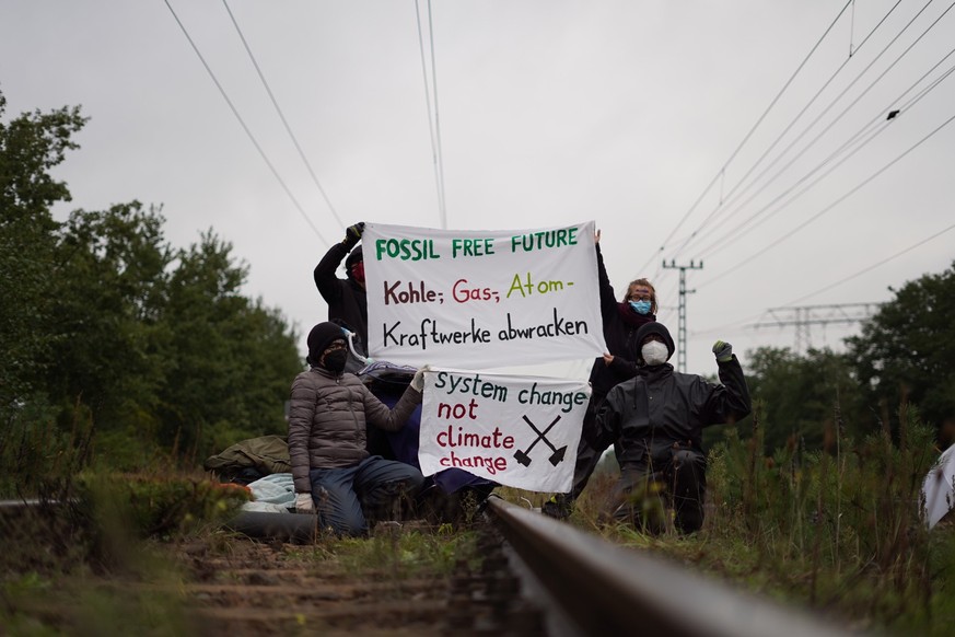 Klimaaktivist:innen blockieren ein Gleis. Sie protestieren gegen die Reaktivierung zweier Reserveblöcke im Kraftwerk Jänschwalde.