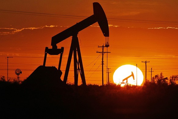 ARCHIV - 11.06.2019, USA, Permbecken: Ein Pumpe arbeitet in einem Ölfeld. Ölkonzerne wie Exxon, BP und Shell stehen in Zeiten der Energiekrise wegen ihrer Mega-Profite unter Druck. Zu Recht? Fragen un ...