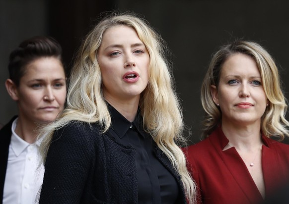 American actress Amber Heard, former wife of actor Johnny Depp, center, with lawyer Jennifer Robinson, right, and partner Bianca Butti, left, gives a statement outside the High Court in London, Tuesda ...