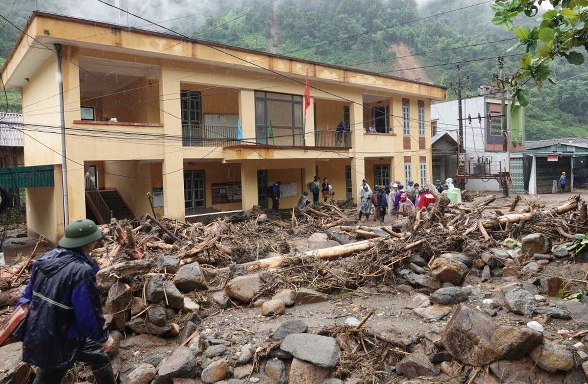 Residents remove debris after heavy rains caused flash floods and landslides in Mu Cang Chai district, Yen Bai province on August 7, 2023. Flash floods and landslides have killed at least eight people ...