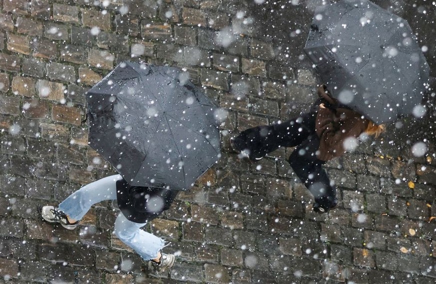 Pedestrians shelter from the rain under umbrellas during a downpour on August 31, 2023 in Berlin, Germany. (Photo by David GANNON / AFP) (Photo by DAVID GANNON/AFP via Getty Images)