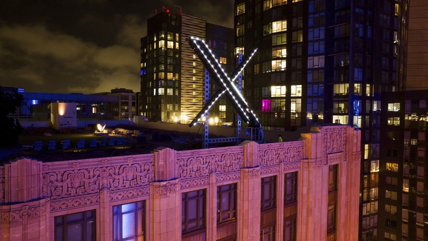 29.07.2023, USA, San Francisco: Arbeiter installieren die Beleuchtung eines &quot;X&quot;-Schildes auf dem Hauptsitz des Unternehmens, das früher als Twitter bekannt war, in der Innenstadt. Foto: Noah ...