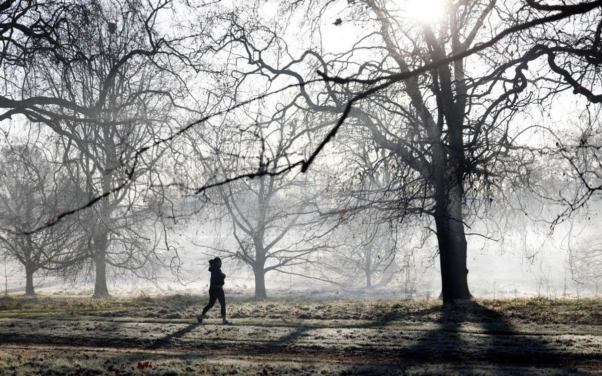 A jogger runs to exercise in a frost-covered Hyde Park in London on January 18, 2022. (Photo by Tolga Akmen / AFP) (Photo by TOLGA AKMEN/AFP via Getty Images)
