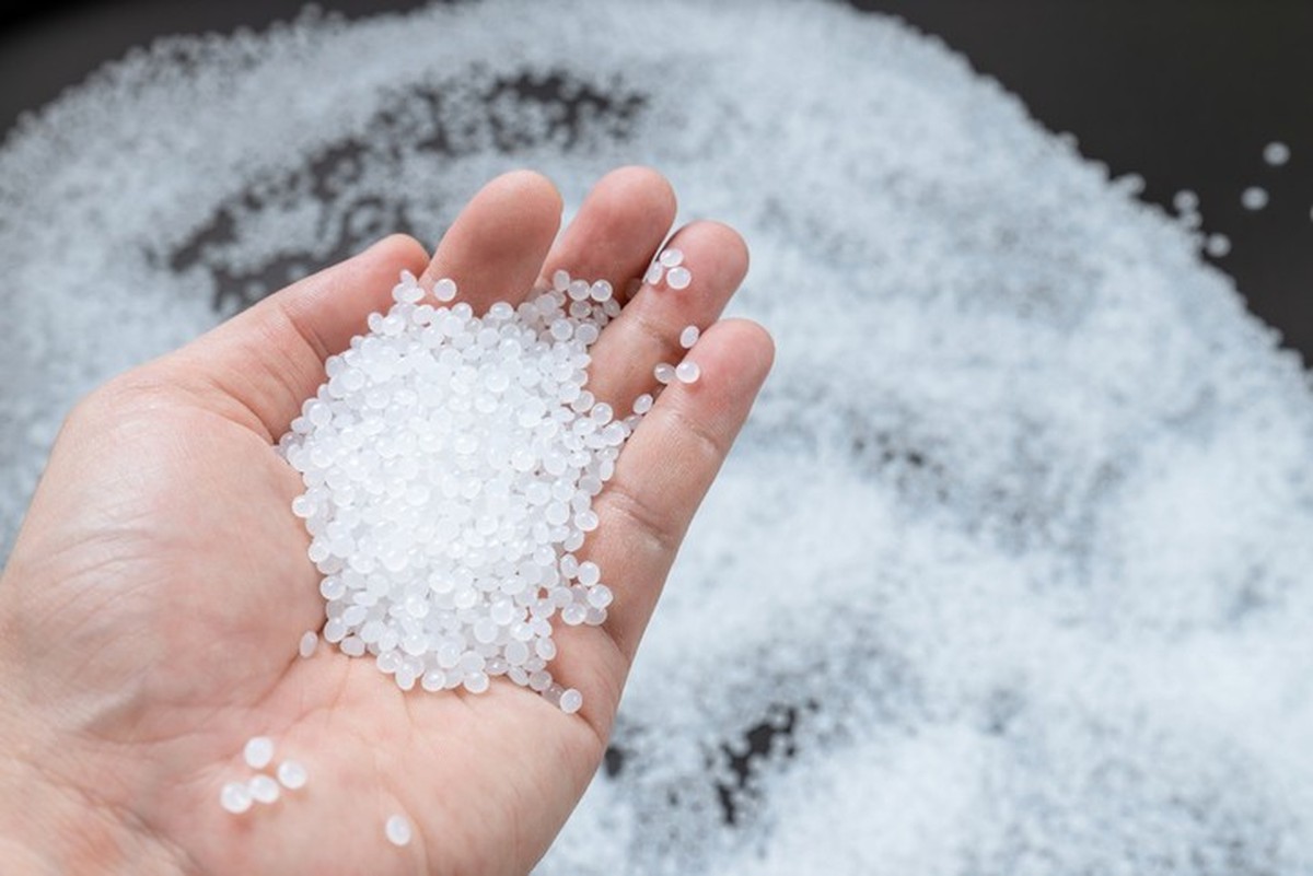 White plastic beads on wood background, Polymers bead or polymer resin, polymer pallet, Product from petrochemical plants. granules polymer,