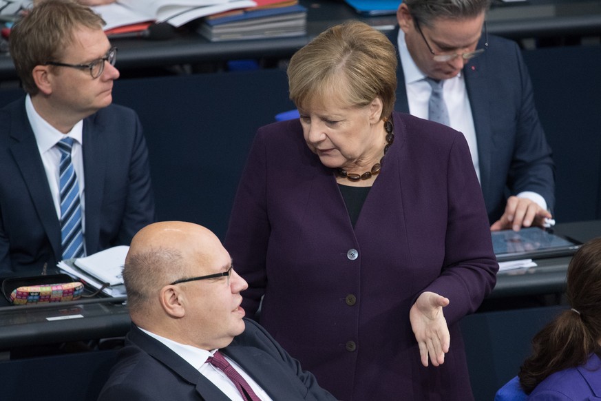 Peter Altmeier (CDU), Bundeswirtschaftsminister, und Bundeskanzlerin Angela Merkel (CDU) unterhalten sich bei der 128. Sitzung des Deutschen Bundestages.
