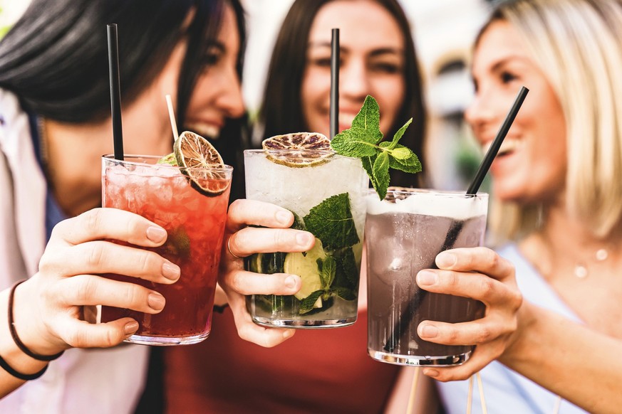 Group of happy friends toasting and drinking fancy cocktails at bar terrace-Three Young girls drink mojito and clinking glass together at pub enjoying happy hour at summer party- Life Style concept