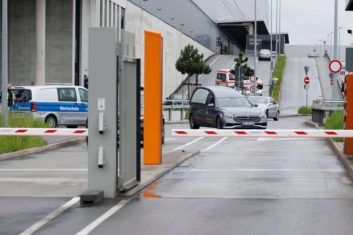 11.05.2023, Baden-Württemberg, Sindelfingen: Zwei Polizisten bewegen sich über das Werksgelände bei Tor 5. Bei Schüssen auf einem Werksgelände von Mercedes-Benz in Sindelfingen gab es Tote. Foto: Juli ...