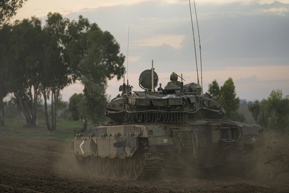 28.11.2023, Israel, ---: Israelische Soldaten fahren einen Panzer am fünften Tag der vorübergehenden Waffenruhe zwischen Israel und der Hamas nahe der Grenze zum Gazastreifen. Foto: Ohad Zwigenberg/AP ...