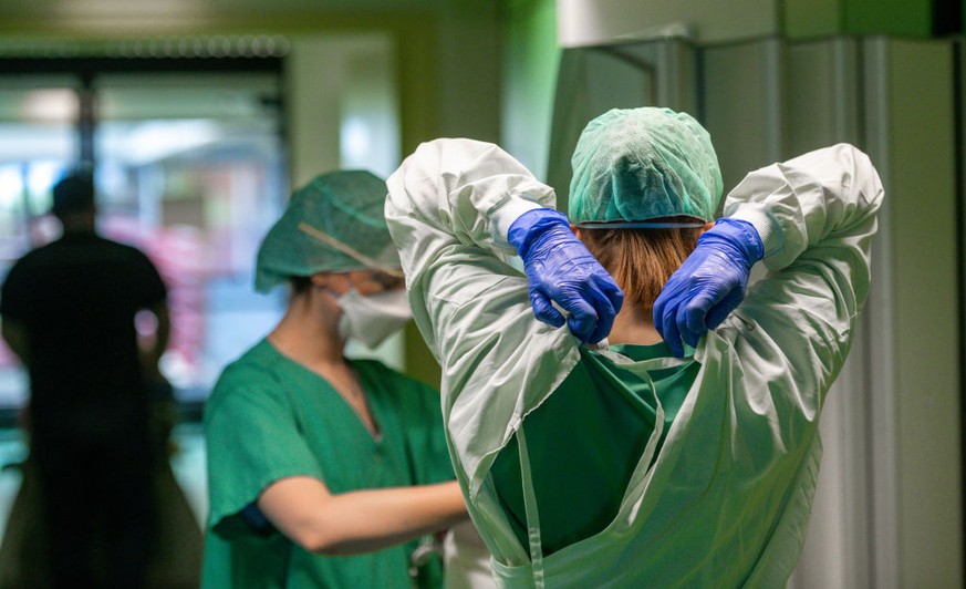 AACHEN, GERMANY - APRIL 09:
Medical staff prepares himself with protective clothing and masks on regular station for contact with Covid-19 patients being treated at Aachen University Hospital during t ...