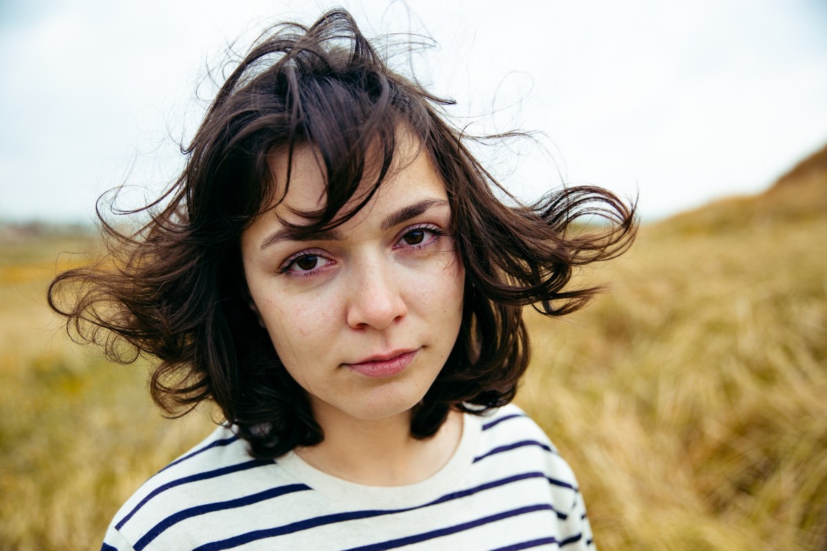 warm diffused light on wheat field. The girl crying and looking at the camera