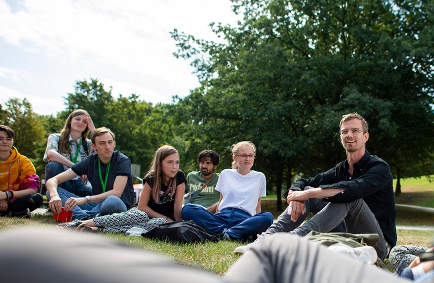 Der Fernsehmoderator Joko Winterscheidt (r) diskutiert im Revierpark mit Teilnehmern des "Sommerkongresses" der Fridays for Future Bewegung.