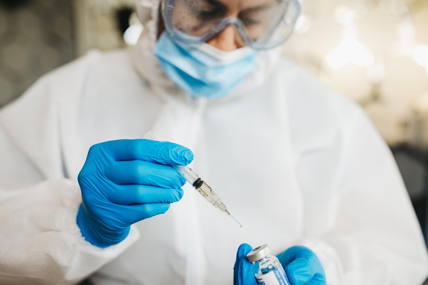 Eine Person arbeitet in einem Labor an einem Impfstoff. (Symbolbild)
