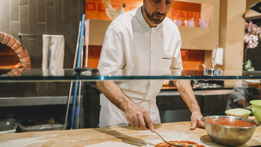 Pizza chef preparing a pizza at the restaurant