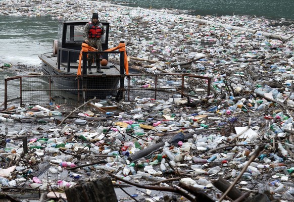 dpatopbilder - ARCHIV - 12.01.2023, Serbien, Priboj: Ein Boot schiebt tonnenweise Müll aus dem Stausee Potpecko. Serbien und andere Balkanländer sind mit kommunalen Abfällen überfordert, nachdem sie j ...