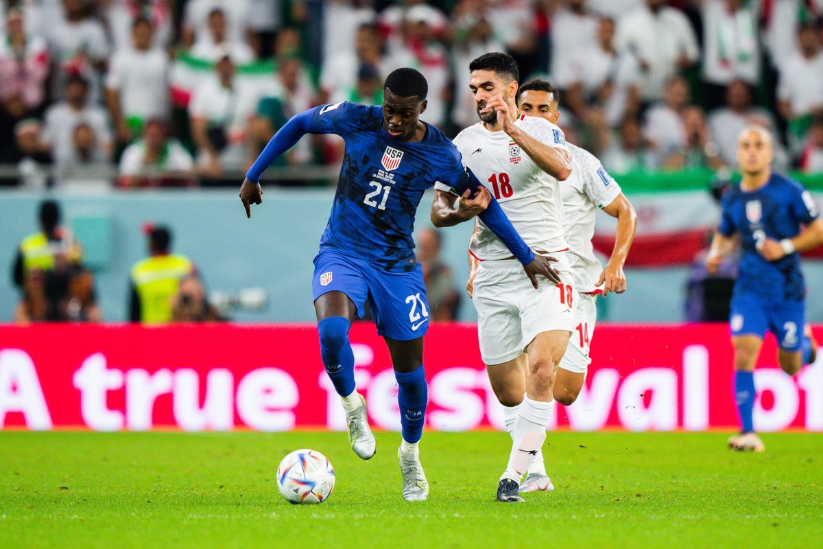 AL THUMAMA, QATAR - NOVEMBER 29: USA Forward Timothy Weah dribbles past Iran midfielder Ali Karimi during the 2022 FIFA World Cup, WM, Weltmeisterschaft, Fussball group B match between USA and Iran on ...
