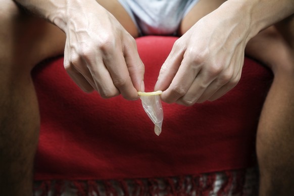 naked man with a condom in his hands