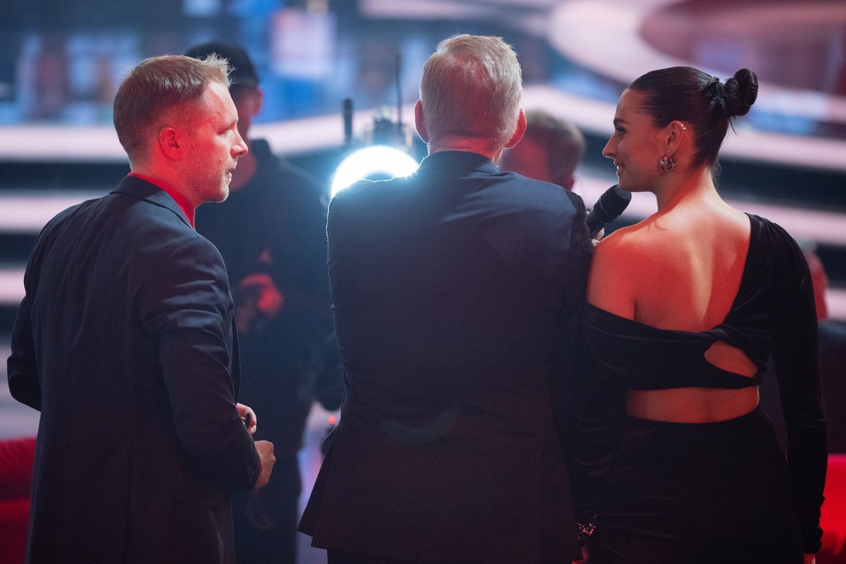 09.12.2023, Berlin: Moderator Johannes B. Kerner (M) steht w�hrend der TV-Spendengala &quot;Ein Herz f�r Kinder&quot; zwischen Oliver Pocher (l), Moderator, und Amira Pocher, Moderatorin. Foto: Sebast ...