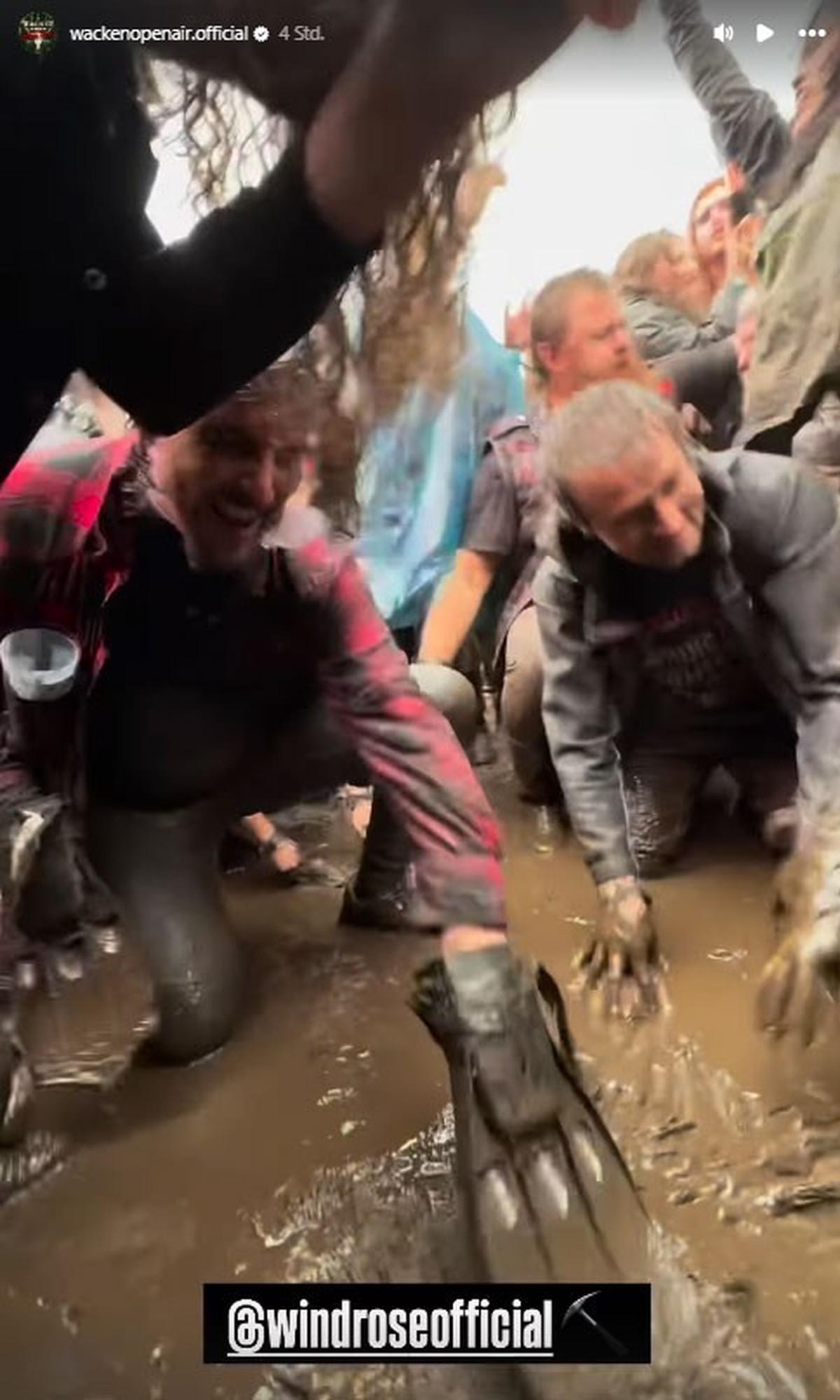 Die Metal-Fans lassen sich die Laune nicht verderben und spielen ein bisschen im Schlamm.