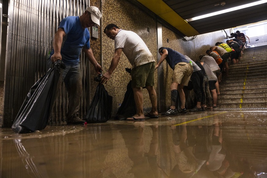 08.09.2023, China, Hongkong: Arbeiter befreien eine MTR-Station nach heftigen Regenfällen. Rekordniederschläge haben in Hongkong zu Überschwemmungen geführt und einen Teil des öffentlichen Lebens lahm ...