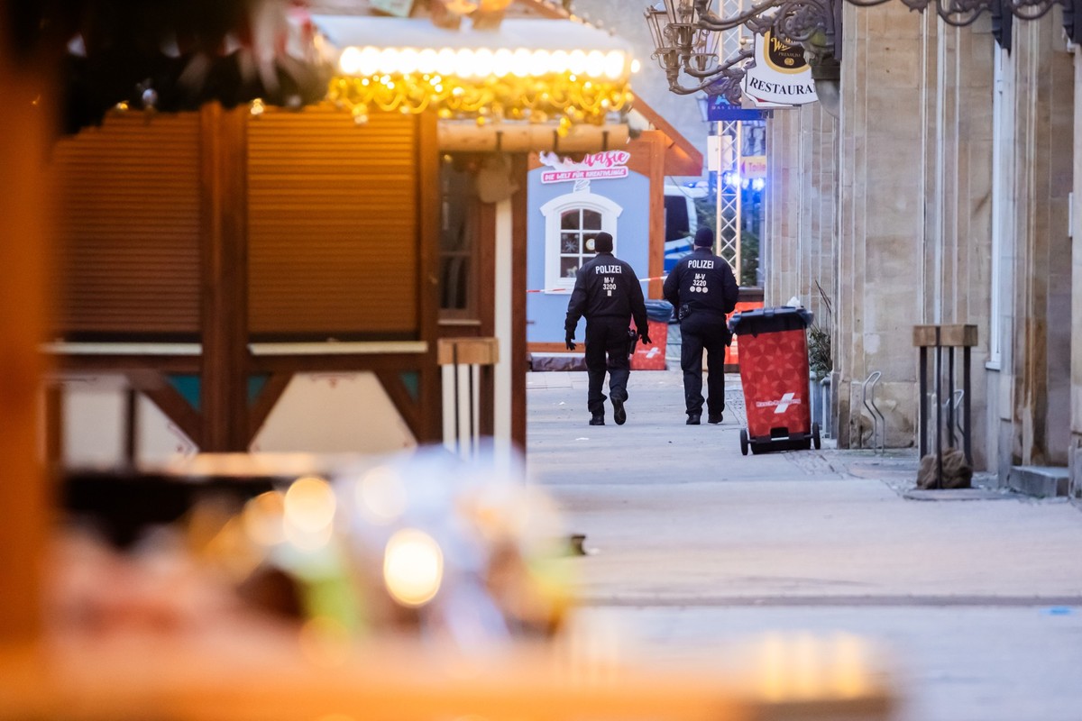 21.12.2024, Sachsen-Anhalt, Magdeburg: Polizisten gehen über den Weihnachtsmarkt. Auf dem Weihnachtsmarkt in Magdeburg ist ein Autofahrer in eine Menschengruppe gefahren. Foto: Christoph Soeder/dpa ++ ...