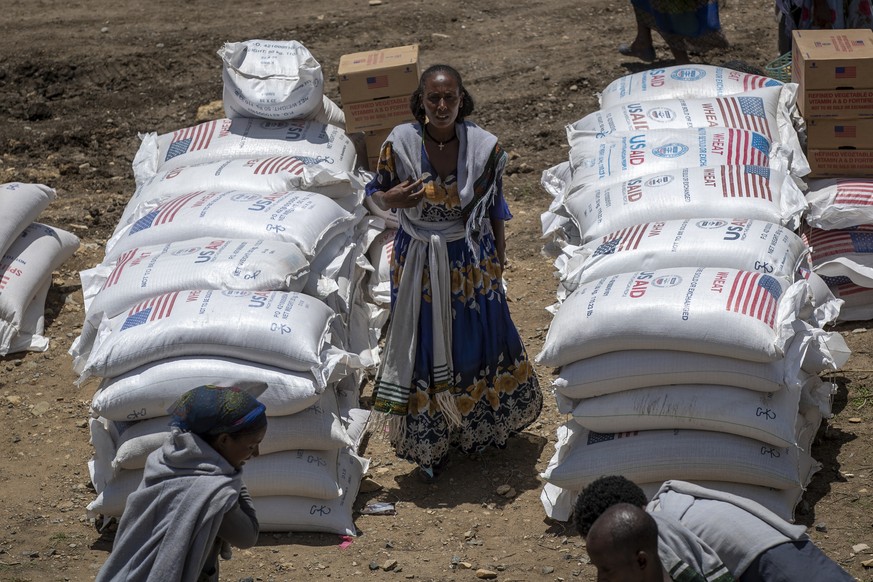 An Ethiopian woman stands by sacks of wheat to be distributed by the Relief Society of Tigray in the town of Agula, in the Tigray region of northern Ethiopia Saturday, May 8, 2021. A high-level U.N.-l ...