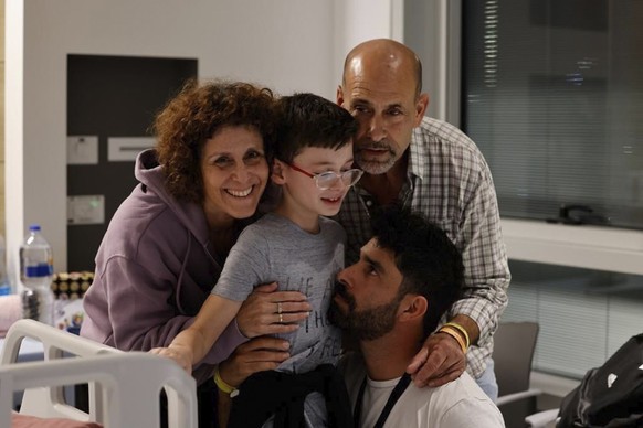 HANDOUT - 25.11.2023, Israel, Petah Tikva: Der 9-jährige Ohad trifft seinen Vater, seinen Bruder und Familienmitglieder im Schneider Children&#039;s Medical Center in Israel nach seiner Freilassung. D ...