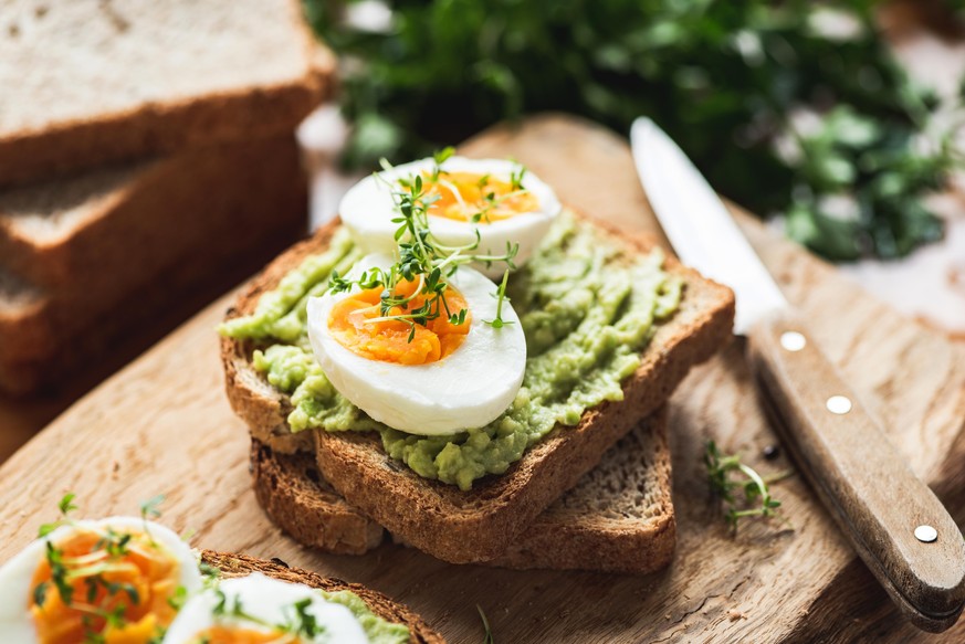 Healhy Breakfast Toast With Avocado, Boiled Egg On Wooden Cutting Board