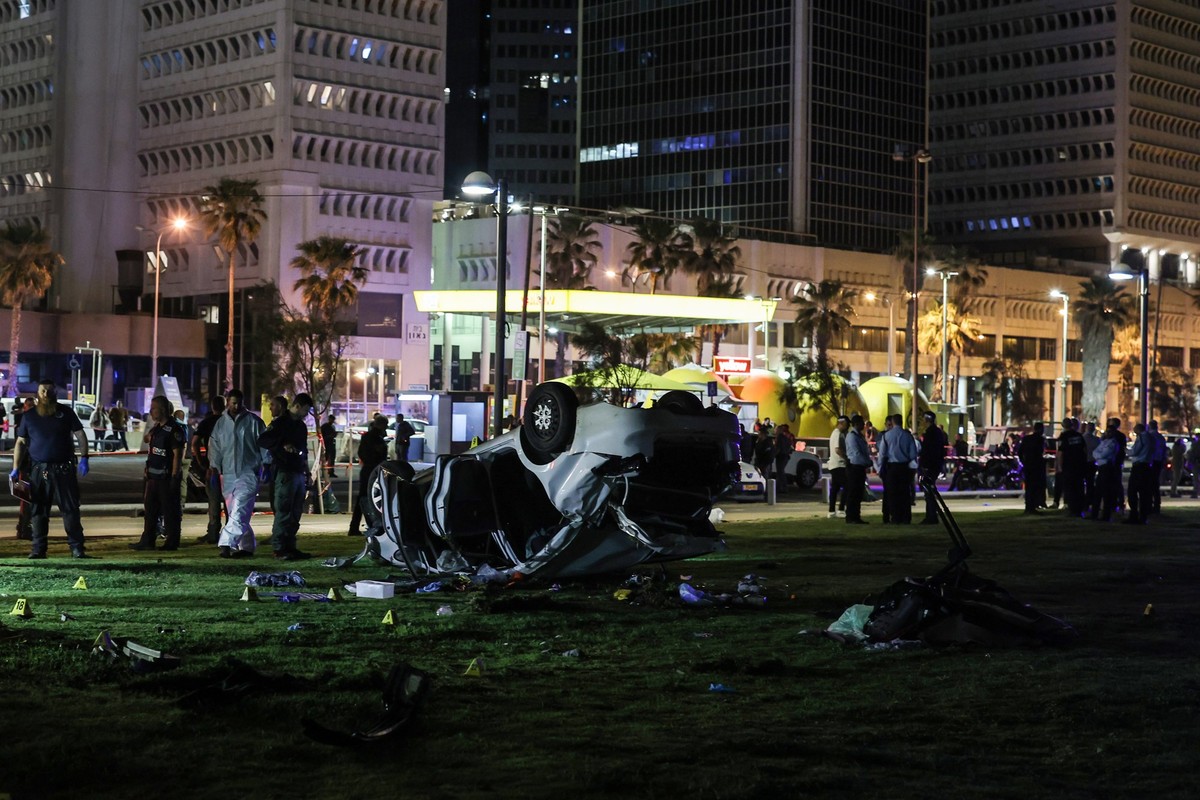 07.04.2023, Israel, Tel Aviv: Israelische Polizisten und Gerichtsmediziner arbeiten am Tatort. Ein Autofahrer rammte mit seinem Wagen Passanten, bevor er sich �berschlug. Bei einem mutma�lichen Anschl ...