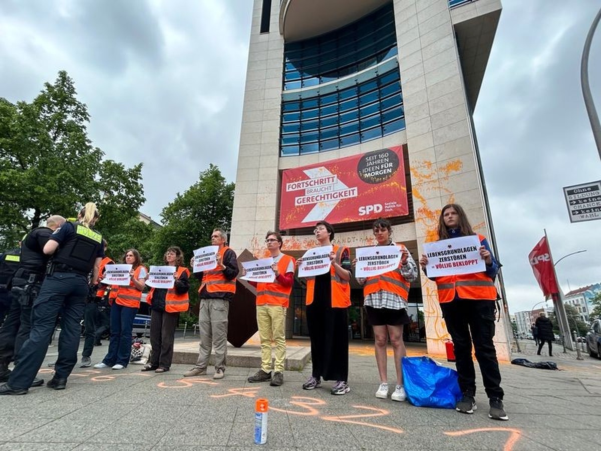 23.05.2023, Berlin: Klimaaktivisten der Gruppe Letzte Generation Demonstrieren vor dem Eingang der Parteizentrale der SPD im Willy-Brandt-Haus und haben orangene Farbe an die Wand gesprüht. Foto: Sven ...