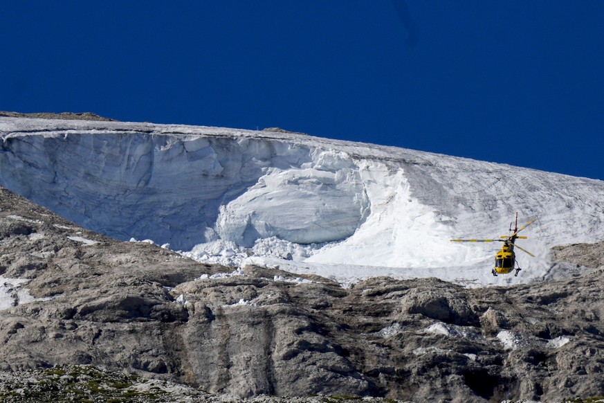 Mit einem Rettungshubschrauber wird über dem Punta-Rocca-Gletscher nach Verletzten gesucht.