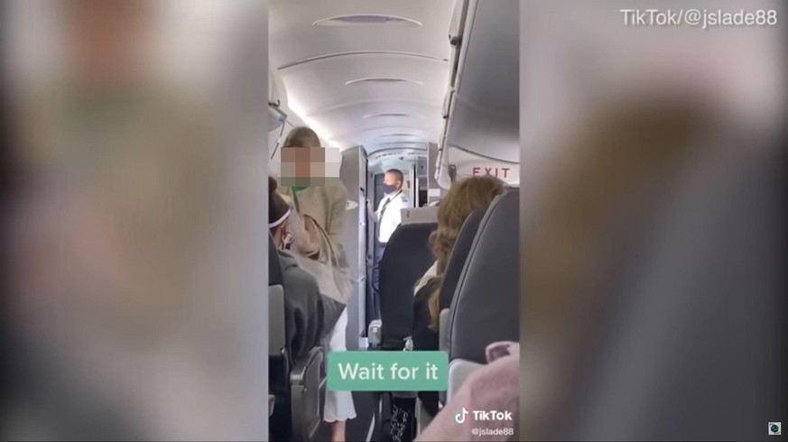 Die maskenlose Frau beim Verlassen des Flugzeugs.