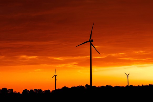 Symbolfoto Windenergie DEU/Deutschland/Brandenburg/Proschim, 13.10.2023, Windraeder sind vor dem von der untergehenden Sonne rot gefaerbten Himmel zu sehen. *** Symbol photo wind energy DEU Germany Br ...