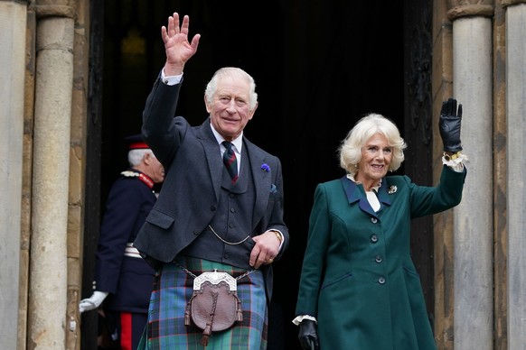 ARCHIV - 03.10.2022, Gro�britannien, Dunfermline: K�nig Charles III. von Gro�britannien und K�nigsgemahlin Camilla winken beim Verlassen der Abbey von Dunfermline. Am 31. M�rz wird das K�nigspaar Hamb ...