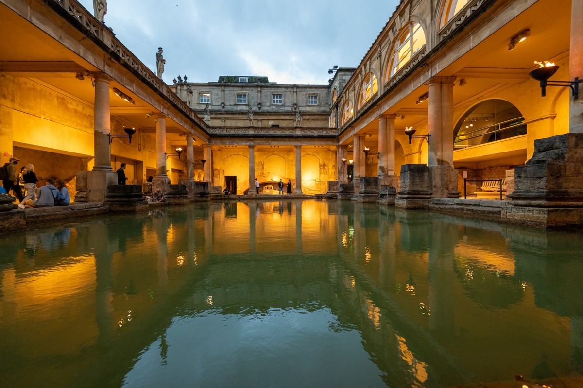 City of Bath, UK. 07-08-2021. Evening sightseeing of restored in Victorian times ancient Roman Baths in the light of wall sconces.