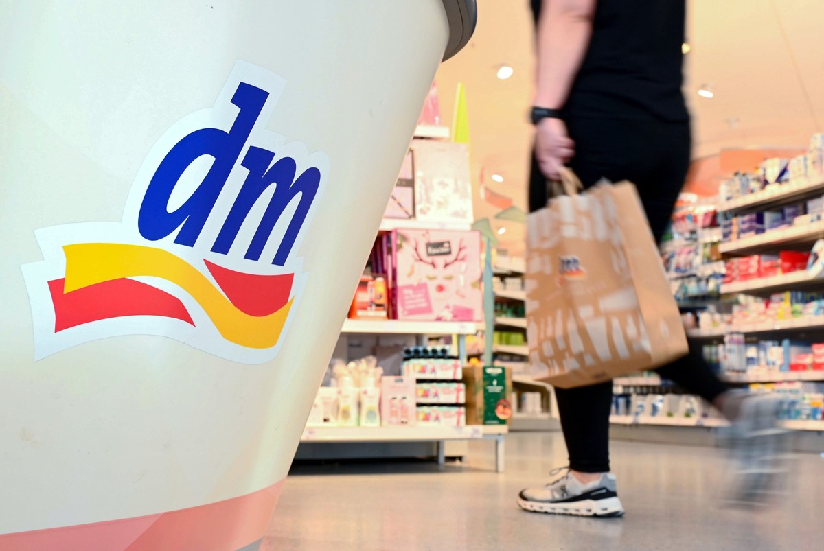 PRODUKTION - 03.11.2022, Baden-Württemberg, Karlsruhe: Eine Person geht in einer Filiale der Drogeriemarktkette dm mit einer Einkaufstüte am Kassenbereich vorbei. Am 10.11.2022 findet die Jahres-Press ...