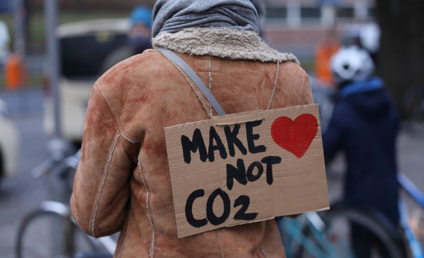 Plakat Make Love Not CO-2 während einer Fahrraddemo gegen neue Autobahnen und für Einhaltung der Klimaschutzziele anlässlich fünf Jahre Pariser Klimaabkommen, Berlin, 12. Dezember 2020. Fahrraddemo Av ...
