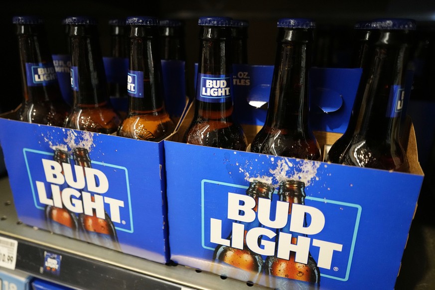 FILE - Bottles of Bud Light beer sit on a shelf at a grocery store on April 25, 2023, in Glenview, Ill. Bud Light&#039;s parent company said Thursday, May 4, that it will triple its marketing spending ...