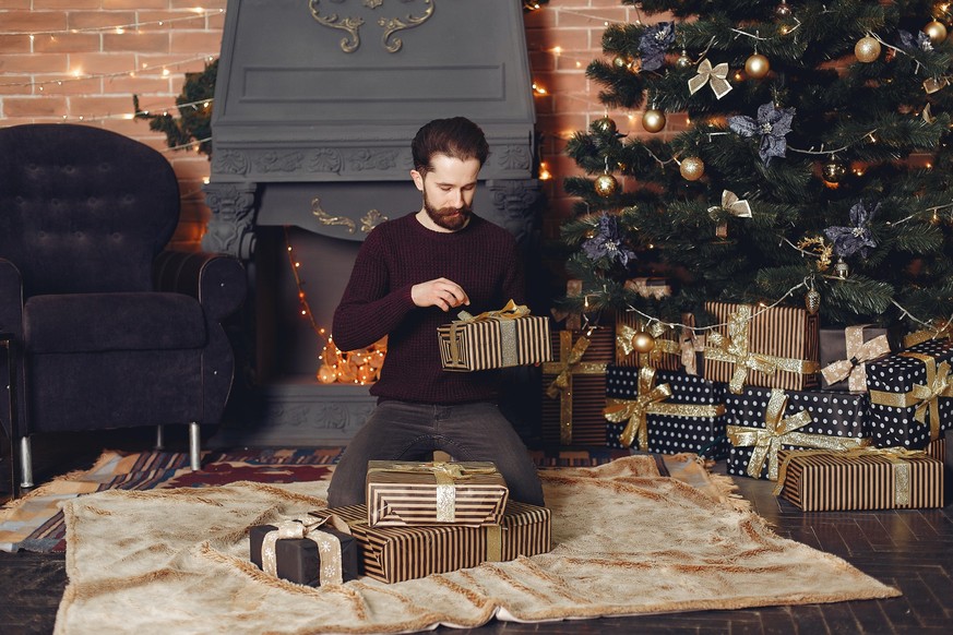 Mann packt Geschenk aus weihnachten