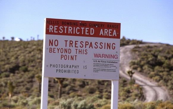 Aug 16, 2013 - Rachel, Nevada, U.S. - A warning sign at the restricted boundary to Area 51 on an unmarked dirt road near the town of Rachel and the UFO Highway (Hwy. 375). A white security vehicle is  ...