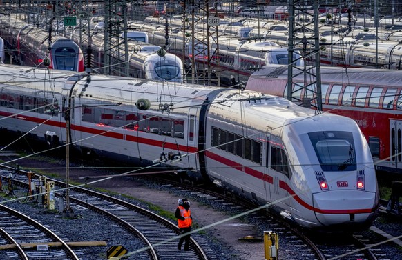 A Deutsche Bahn employee walks past ICE trains that are parked near the central train station in Frankfurt, Germany, Monday, March 27, 2023. Germany faces a nationwide public transport strike on Monda ...