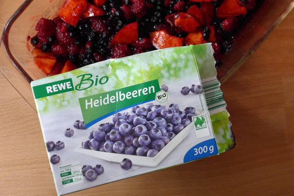 Tiefgekühlte Bio-Heidelbeeren der Handelskette Rewe als Zutat zu einer Obstquarkspeise. Die Verpackung trägt ein Ökosiegel der EU. Laut Aufschrift wurden die Früchte per Hand im Wald gepflückt. Bei An ...