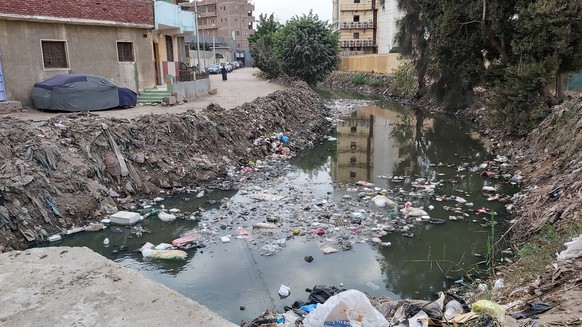 Dirty street and channel with water in Egypt